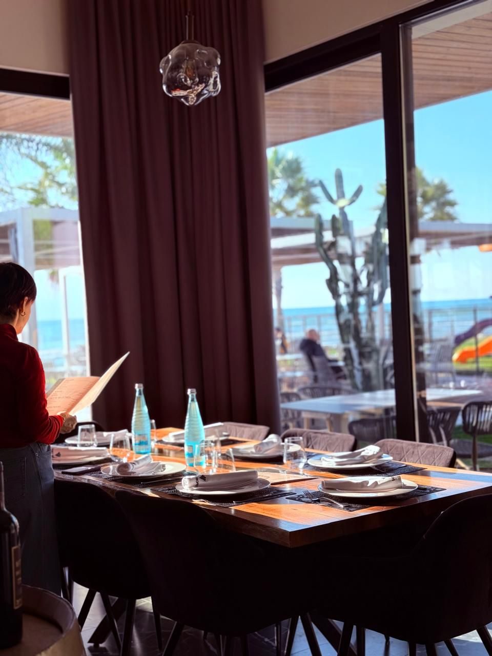 Elegant interior dining room at Saint Tropez with sea views through floor-to-ceiling windows in Vlorë